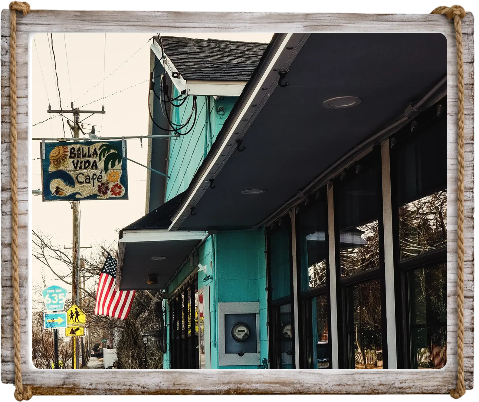 Exterior of a cozy cafe with a rustic sign and American flag.
