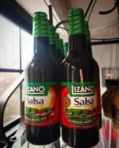 Two bottles of Lizano Salsa sauce on a shelf.