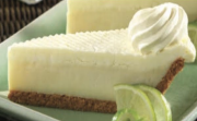 A slice of creamy key lime pie with a dollop of whipped cream.