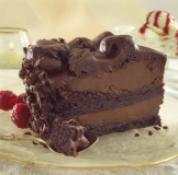A rich slice of chocolate cake with cherries on the side.