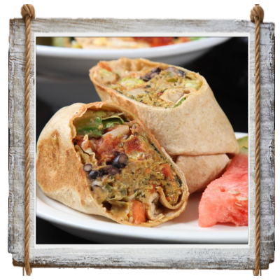 Two halves of a stuffed wrap on a white plate with a red sauce side.