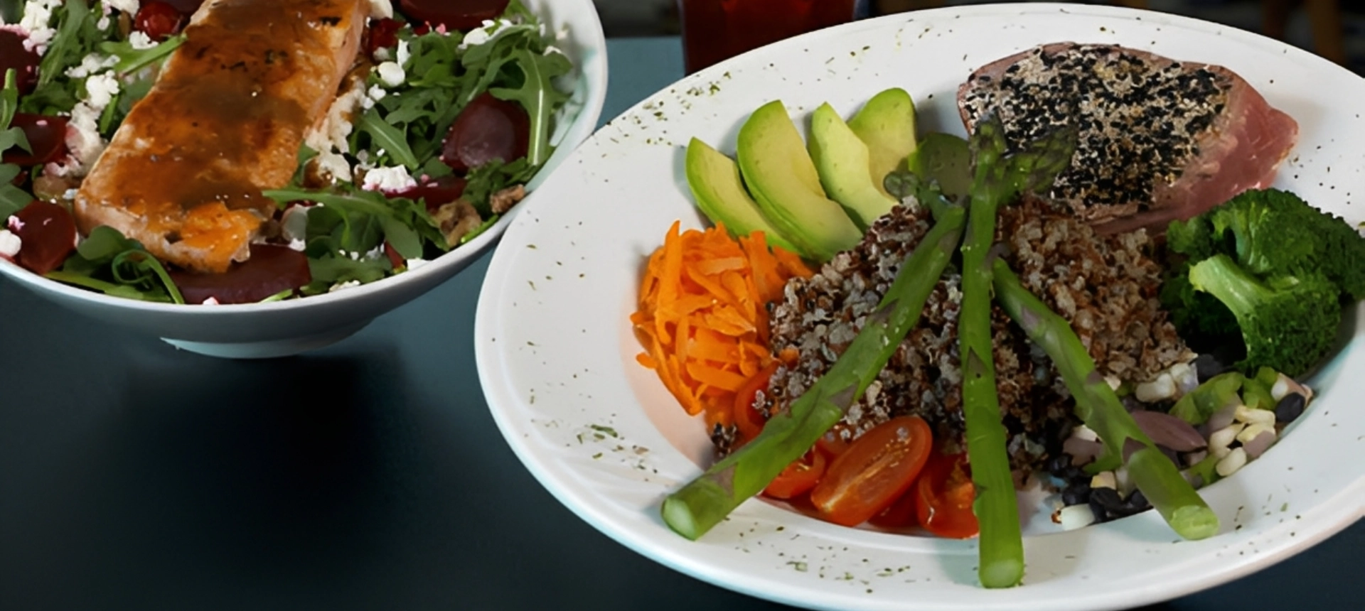 A healthy bowl with avocado, carrot, quinoa, asparagus, and tomato.