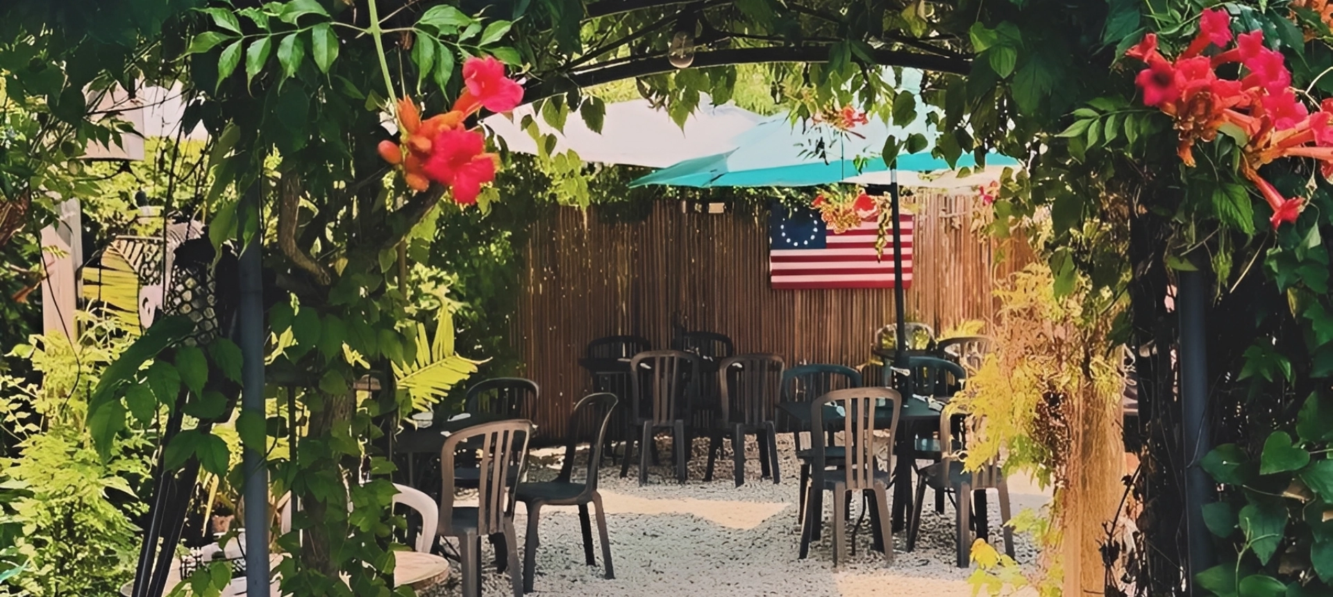 Outdoor seating area with chairs, flowers, and an American flag.